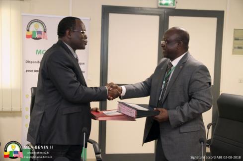 Echange de parapheurs lors de la signature de l'accord de mise de mise en oeuvre entre MCA-Bénin II et l'ABE