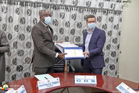 Echange de dossiers entre Alexis REHBINDER, représentant l'entreprise GDS, et le Directeur Général de l'ABERME à la suite de la signature du titre l’exploitation de mini-réseaux électriques au Bénin
